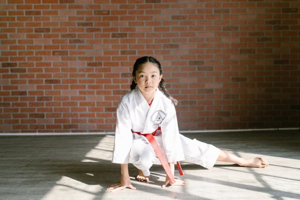 pexels-photo-7045754 A young girl practicing martial arts indoors, showcasing concentration in her gi.